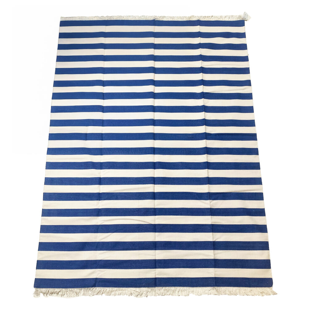 A blue and white striped cotton rug from the design showroom AOI Home.