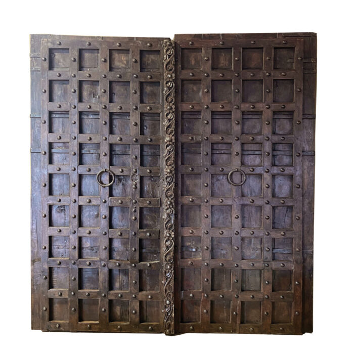 A large antique Indian door with fine details from the Dallas showroom AOI Home.