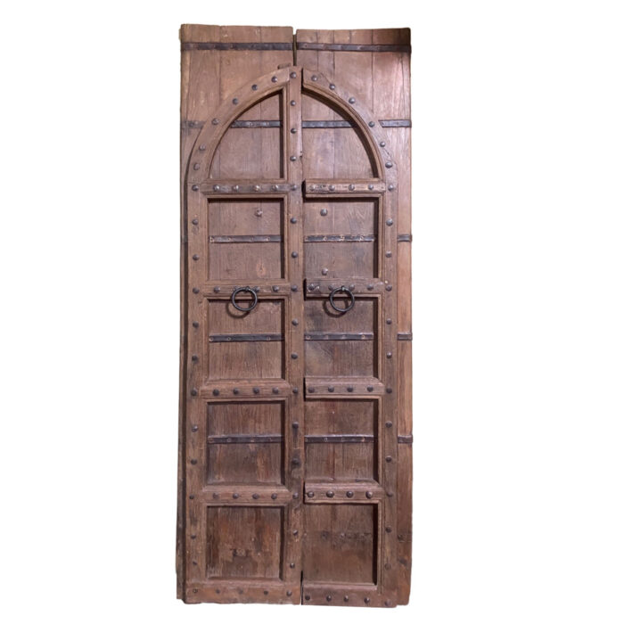 An antique Indian door carved with an arched Mihrab shape and located in the Dallas design shop AOI Home.