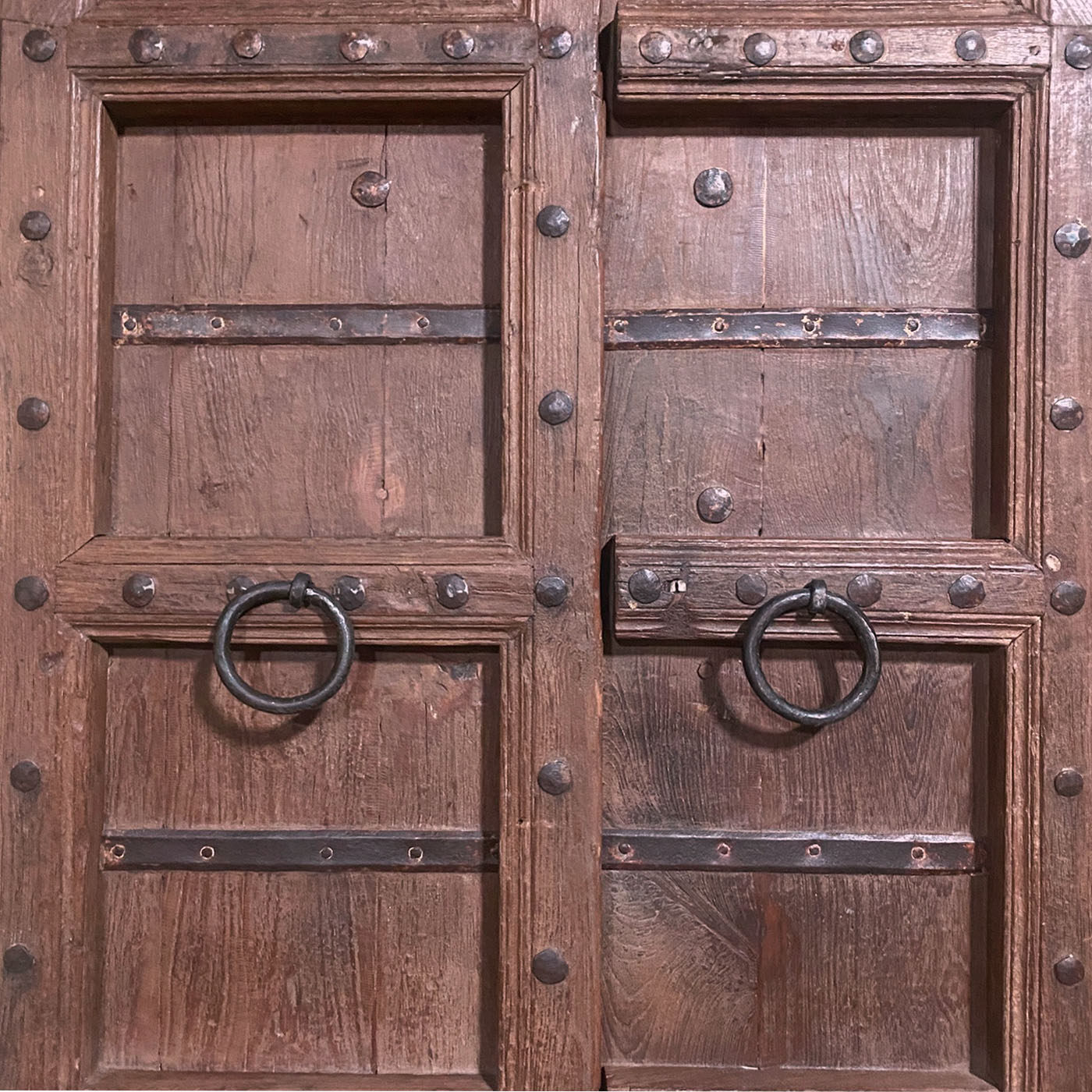 An antique Indian door carved with an arched Mihrab shape and located in the Dallas design shop AOI Home.