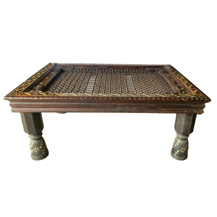 A rectangular coffee table with bone inlay and a iron grill top from the design shop AOI Home.